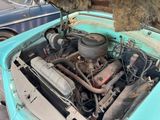 an old blue car with its engine in the trunk of it