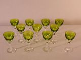 many green wine glasses lined up on a white table