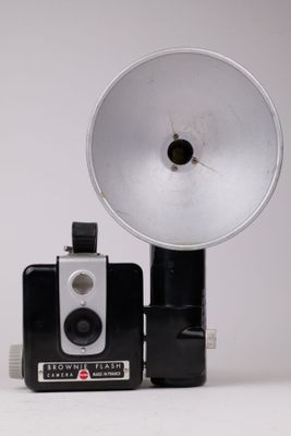 une photo en noir et blanc représentant un appareil photo et une lampe