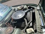 un moteur de voiture dont le capot est ouvert, garé dans la rue
