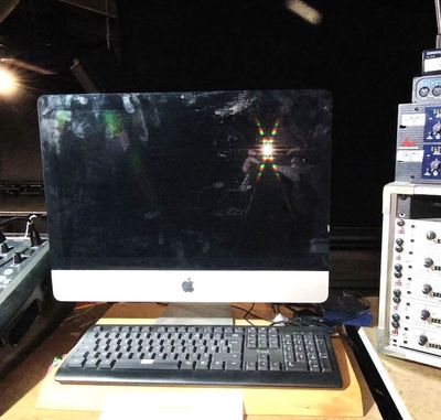 un écran d'ordinateur et un clavier posés sur un bureau dans un studio d'enregistrement