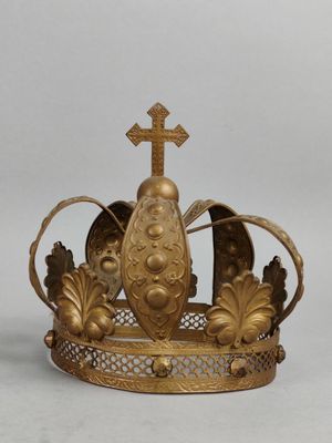 une couronne en or surmontée d'une croix, posée sur une table