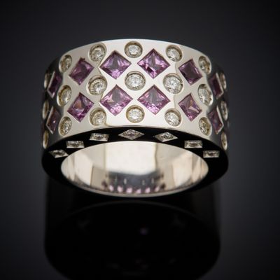 a close up of a ring with diamonds on a black surface