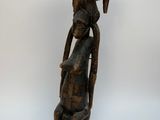 an old wooden statue of a woman with a basket on her head