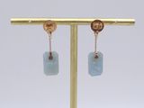 a close up of a pair of earrings on a gold stand