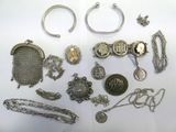 a lot of silver jewelry on a white surface