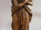 an image of a wooden statue of a woman holding a baby