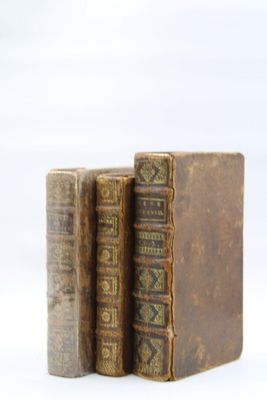 deux vieux livres posés l'un sur l'autre sur une surface blanche