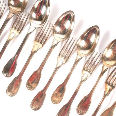 un grand nombre de cuillères et de fourchettes en argent sur une surface blanche
