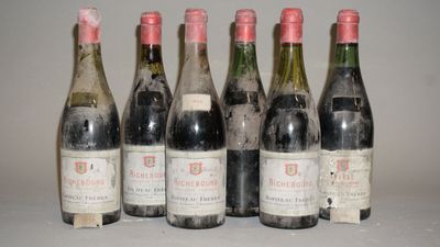 six bouteilles de vin sont alignées sur une table