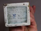 someone is holding a small ceramic box with writing on it