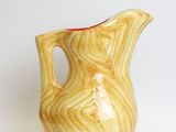 beige and red ceramic pitcher on white background with white background