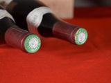 two bottles of wine sitting on a red cloth
