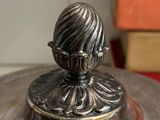 a silver vase sitting on top of a wooden table