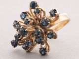 a close up of a gold ring with blue sapphires