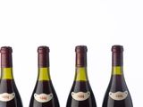 three bottles of wine are lined up on a white surface