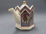 a white teapot with a picture of a man on it
