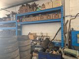 many tires stacked on a shelf in a garage