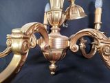 a gold colored chandelier with three lights on it