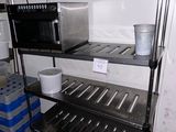 a metal shelf with a microwave and a basket on it