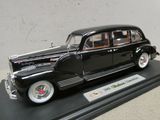 une maquette de voiture noire posée sur un socle noir