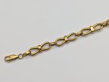 a close up of a gold chain on a white surface