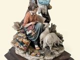 figurine représentant un homme et une femme assis sur un rocher avec un chien