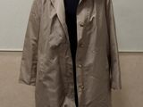 an image of a coat on a mannequin stand in front of a wall