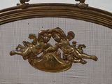 a gold colored fire screen with cherensils on it