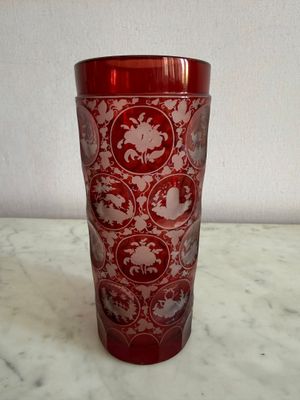 un verre rouge décoré d'un motif, posé sur une table