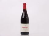 une bouteille de vin rouge posée sur une table blanche