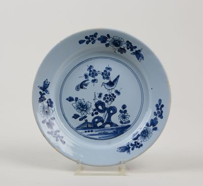 a blue and white plate with flowers and birds on it
