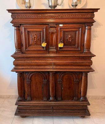 une grande armoire en bois sur laquelle sont posés trois vases