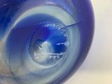 a blue glass vase sitting on top of a table