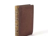an old book sitting on top of a table next to a white background