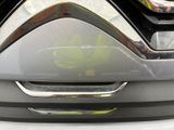 a close up of a car ' s front bumper with a leaf on it