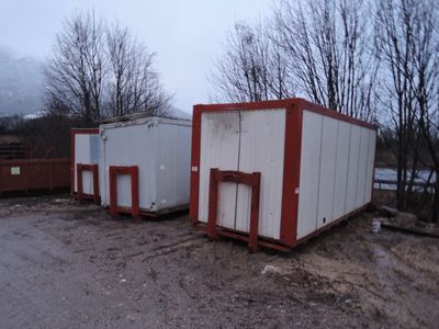 deux conteneurs blancs et rouges posés au bord de la route