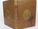 an old book with a gold cover and a cross on the front