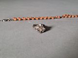 un gros plan d'un collier en perles sur lequel est accrochée une bague