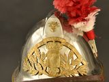 a silver helmet with a red flower on top of it