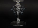 a glass candle holder with a candle on top of it