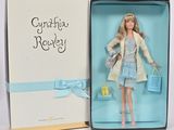 La poupée Barbie se trouve dans une boîte ornée d'un ruban bleu