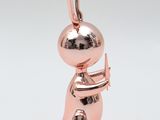 an image of a pink gold pendant with a person holding a knife