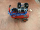 a small air compressor sitting on the ground