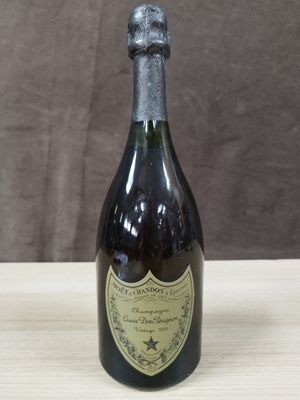 une photo d'une bouteille de champagne posée sur une table en bois