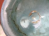 a close up of a blue vase with a ring in it