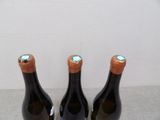 three bottles of wine are sitting on a table with a cork stopper