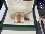 a rolex watch in a box on a table with silverware