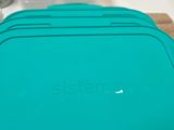 a blue suitcase sitting on top of a wooden cutting board