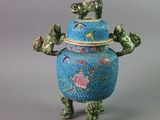 a blue vase with a bird and flowers on it